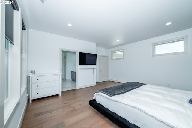 bedroom featuring hardwood / wood-style flooring and ensuite bathroom