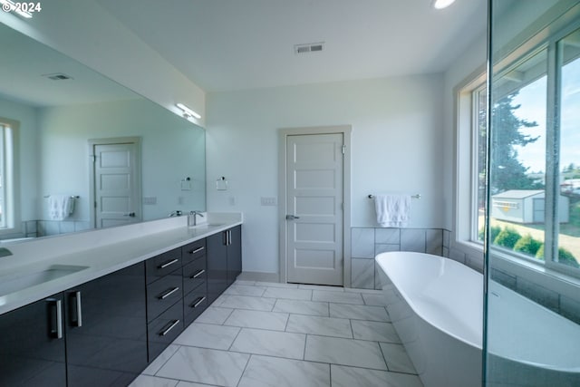 bathroom featuring a bath, tile patterned floors, vanity, and a healthy amount of sunlight