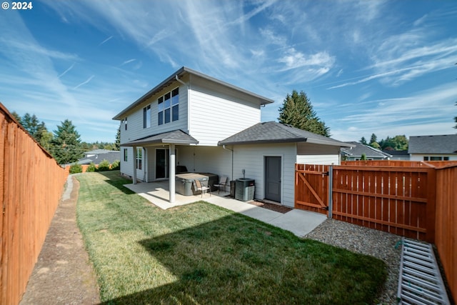 back of house featuring cooling unit, a lawn, and a patio area