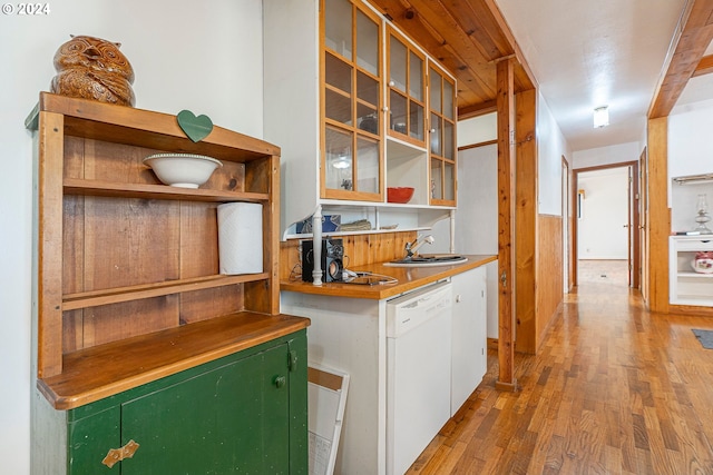 bar featuring sink, light wood-type flooring, and white dishwasher