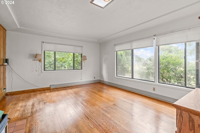 spare room featuring a textured ceiling and light wood-type flooring