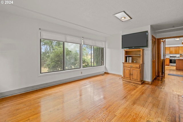 unfurnished bedroom with light hardwood / wood-style floors and a baseboard radiator