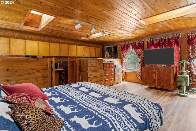 bedroom with wood walls, a skylight, wood ceiling, and light hardwood / wood-style floors