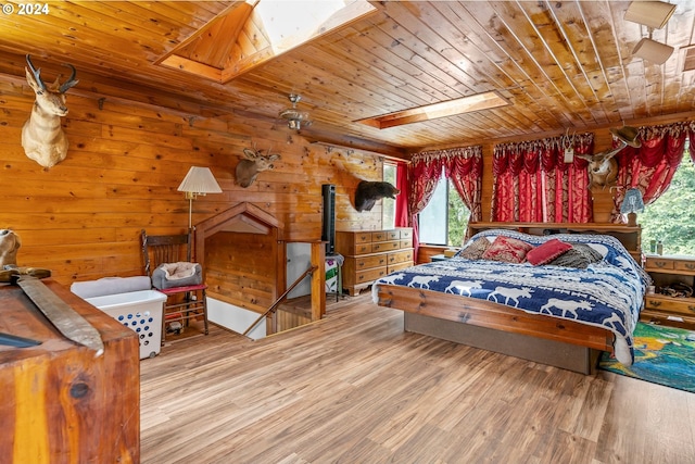 bedroom with wooden ceiling, light wood-type flooring, and a skylight