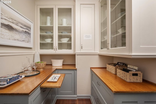 bar featuring dark hardwood / wood-style flooring, white cabinetry, and gray cabinets