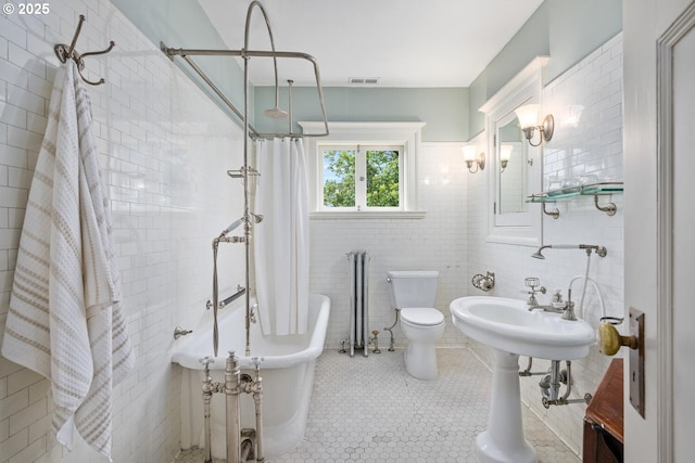 bathroom with tile walls, tile patterned flooring, and toilet