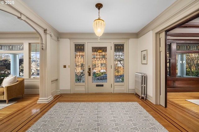 doorway featuring ornamental molding, radiator, and hardwood / wood-style floors