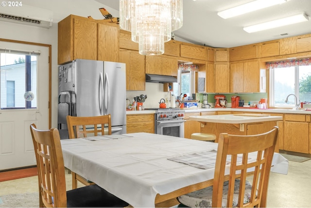 kitchen with sink, a kitchen island, a wall mounted AC, appliances with stainless steel finishes, and a notable chandelier