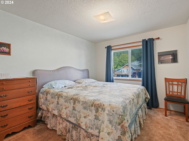 bedroom featuring light carpet and a textured ceiling