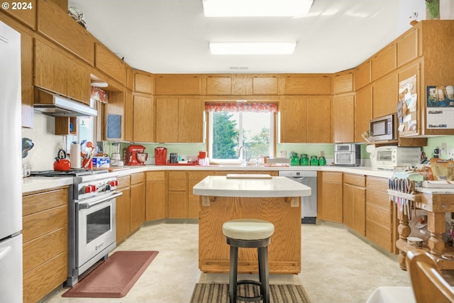 kitchen featuring stainless steel appliances, under cabinet range hood, light countertops, and light flooring
