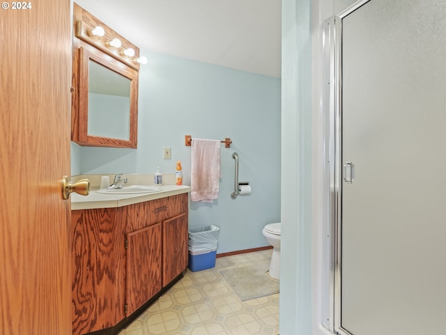 bathroom with a stall shower, toilet, and vanity