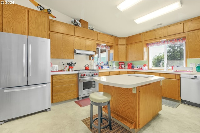 kitchen featuring sink, a breakfast bar area, lofted ceiling, a kitchen island, and appliances with stainless steel finishes