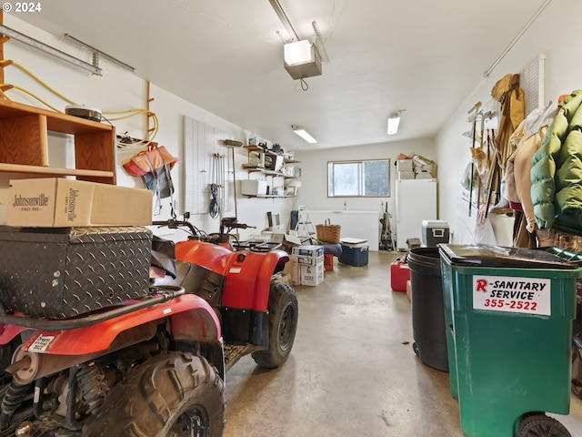 garage with a garage door opener and freestanding refrigerator