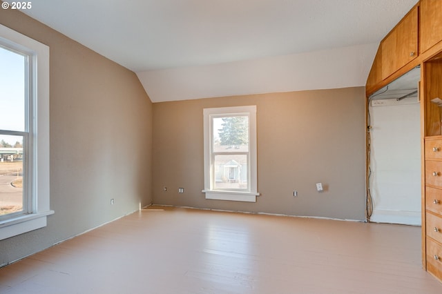 unfurnished room with light hardwood / wood-style floors and vaulted ceiling