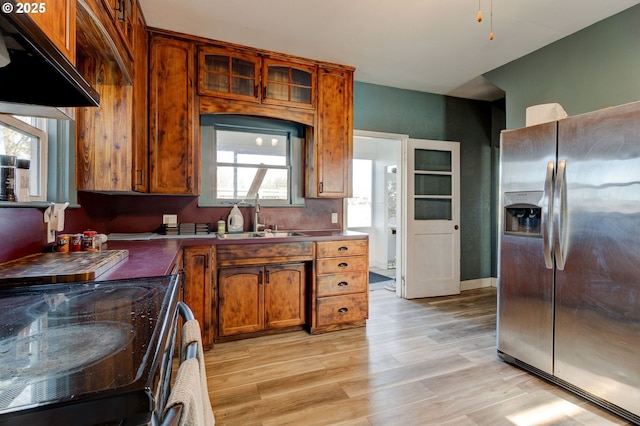 kitchen featuring range with electric stovetop, stainless steel refrigerator with ice dispenser, sink, and light hardwood / wood-style flooring