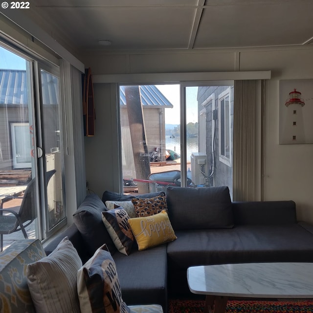 living room featuring a water view and a healthy amount of sunlight