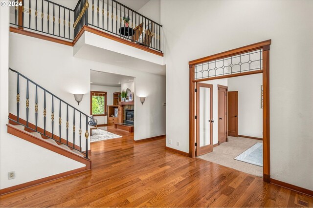 foyer entrance with wood-type flooring and a towering ceiling