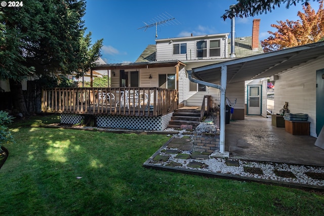 rear view of property featuring a lawn, a patio, and a deck