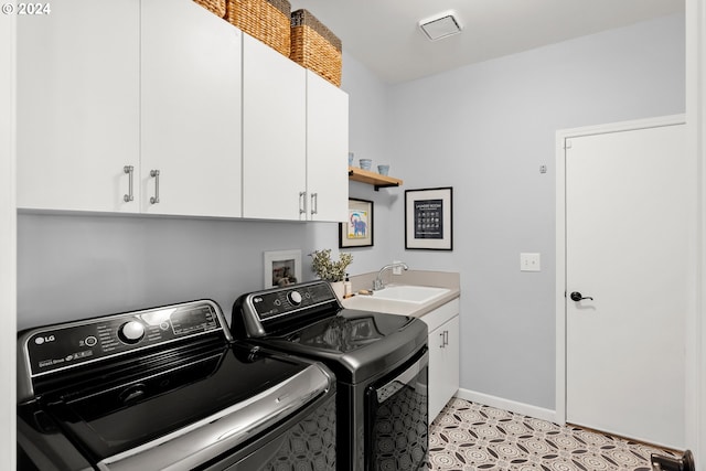 washroom featuring cabinets, sink, and washing machine and clothes dryer