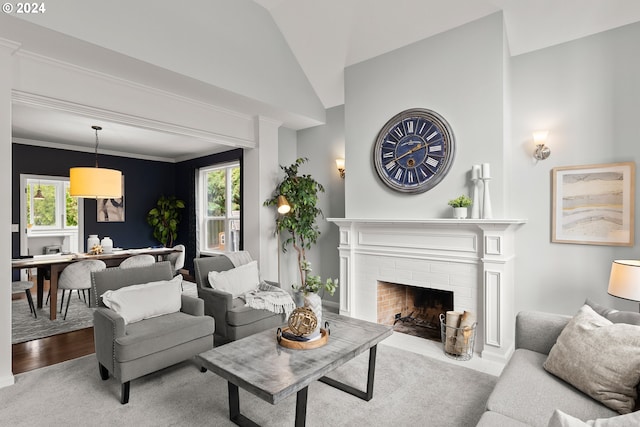 living room featuring light hardwood / wood-style flooring, lofted ceiling, a fireplace, and plenty of natural light