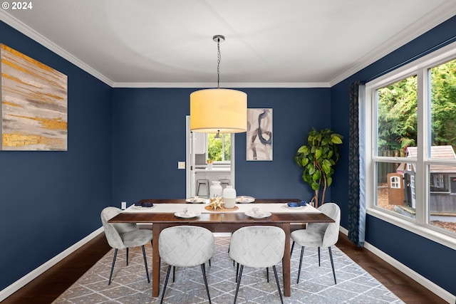 dining area featuring dark wood-type flooring and crown molding