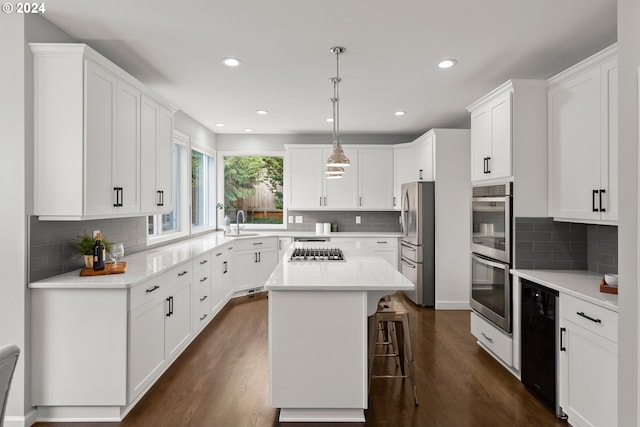 kitchen with a kitchen island, appliances with stainless steel finishes, and white cabinets