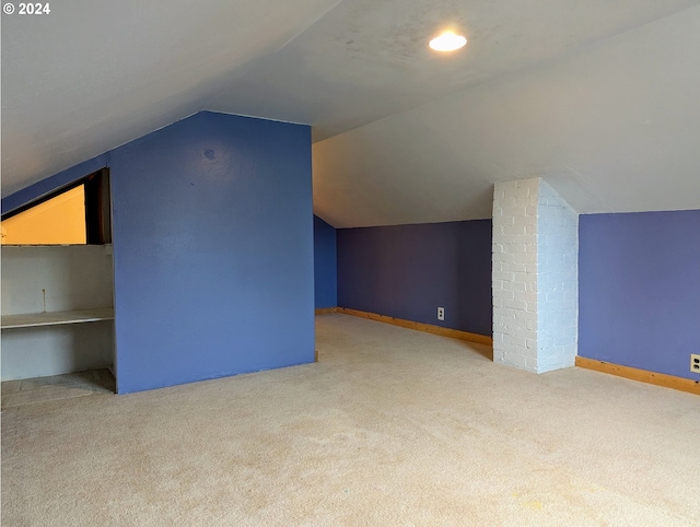 bonus room with light carpet and vaulted ceiling