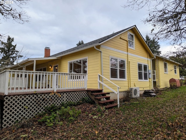 back of house with a wooden deck and ac unit