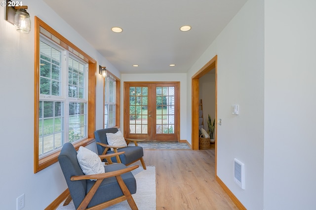 sitting room featuring plenty of natural light, light hardwood / wood-style floors, and french doors