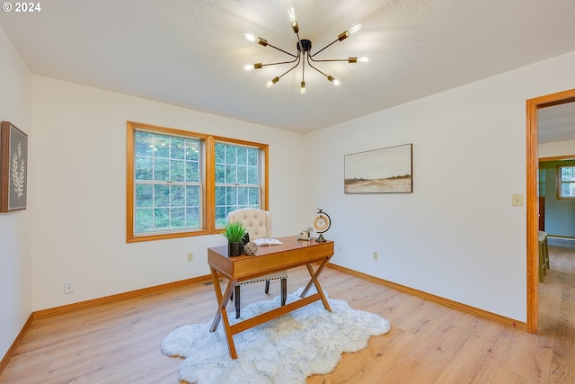 home office with a chandelier and light wood-type flooring