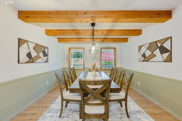 dining room with beam ceiling and light hardwood / wood-style floors