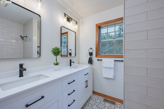 bathroom featuring tiled shower and vanity