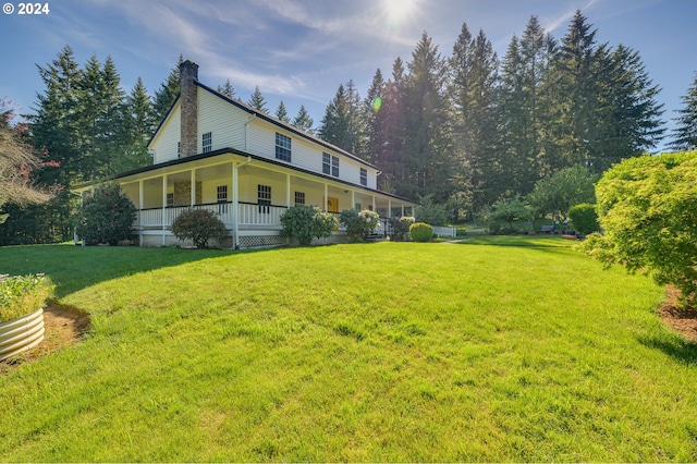 view of side of property featuring covered porch and a lawn