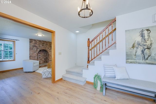 stairway with a chandelier and wood-type flooring