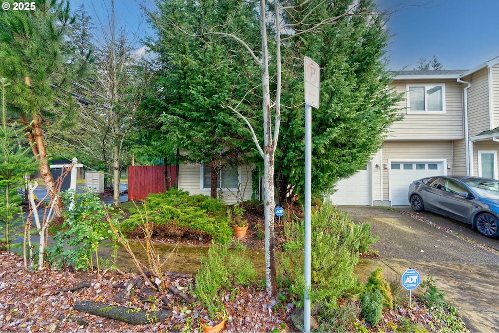 view of property hidden behind natural elements with a garage