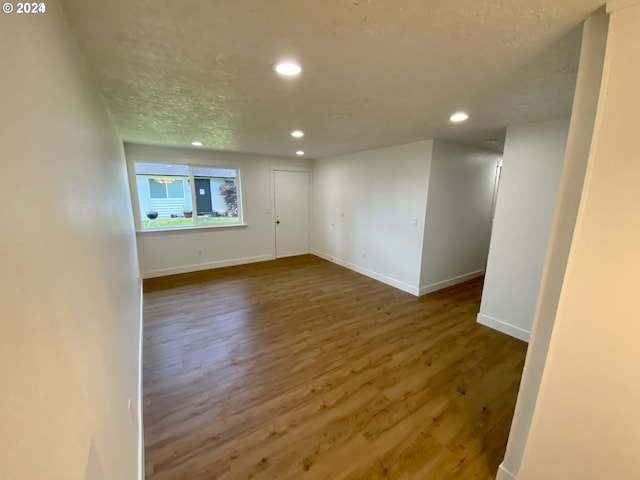 empty room with hardwood / wood-style flooring and a textured ceiling