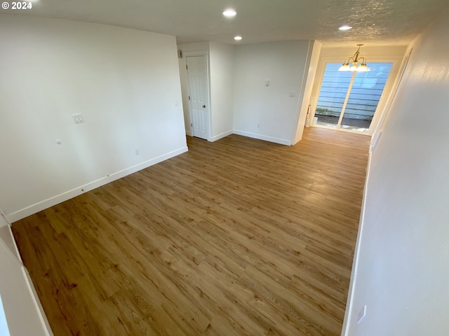 unfurnished room featuring hardwood / wood-style floors and a chandelier