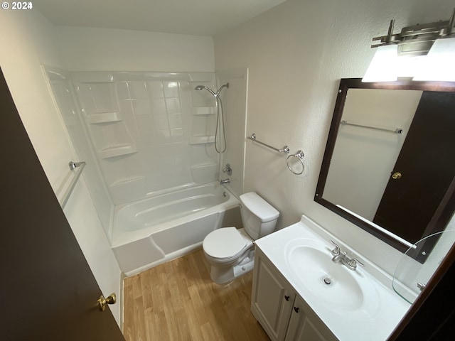 full bathroom with hardwood / wood-style flooring, washtub / shower combination, vanity, and toilet