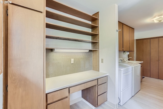 washroom with cabinets, light wood-type flooring, and separate washer and dryer