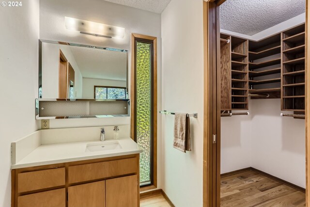 bathroom with vanity, hardwood / wood-style flooring, and a textured ceiling