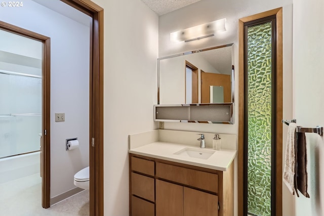 bathroom featuring walk in shower, vanity, toilet, and a textured ceiling