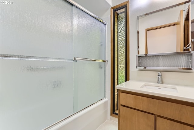 bathroom featuring bath / shower combo with glass door and vanity