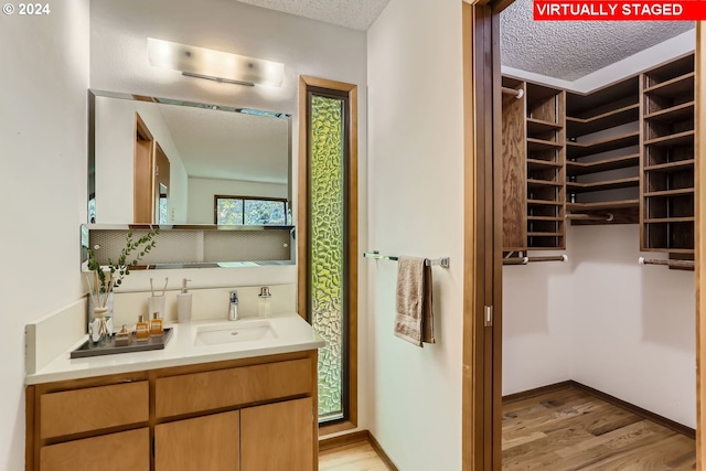 bathroom with vanity, a textured ceiling, and hardwood / wood-style floors