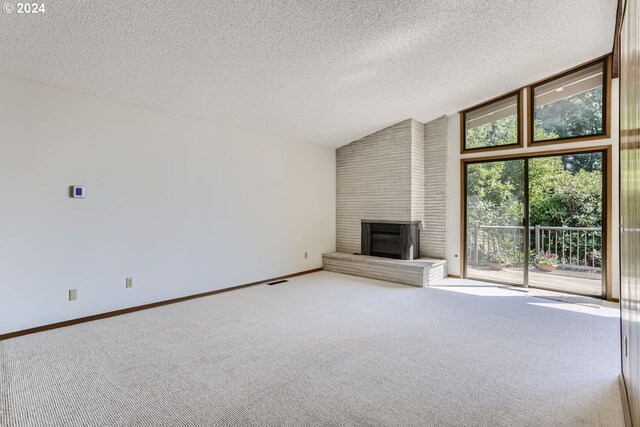 unfurnished living room featuring a textured ceiling, a fireplace, carpet flooring, and high vaulted ceiling