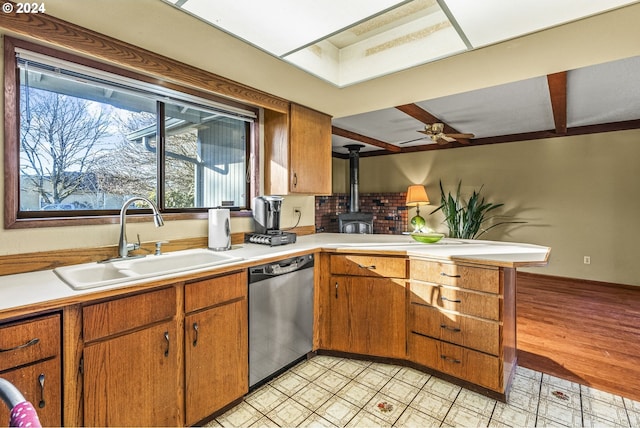 kitchen with dishwasher, a wood stove, sink, light hardwood / wood-style floors, and kitchen peninsula