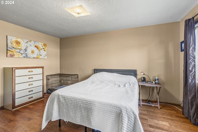 bedroom featuring wood-type flooring and a textured ceiling