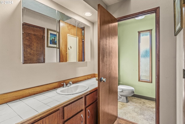 bathroom with hardwood / wood-style floors, vanity, and toilet