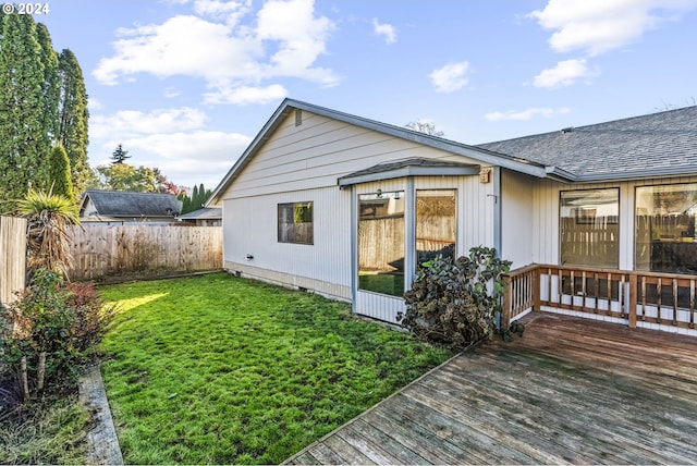 back of house with a lawn and a deck