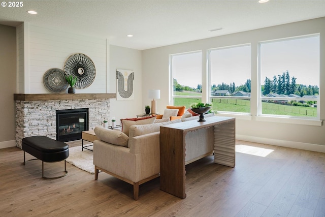 4211 N 11th Way, Ridgefield, WA 98642 - living room with wood finished floors, baseboards, a stone fireplace, and recessed lighting