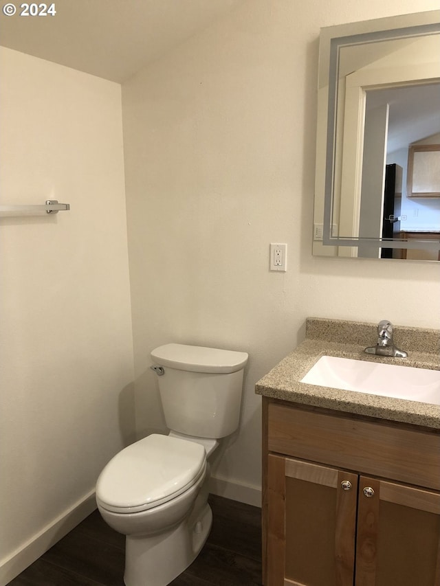 bathroom featuring hardwood / wood-style flooring, vanity, and toilet